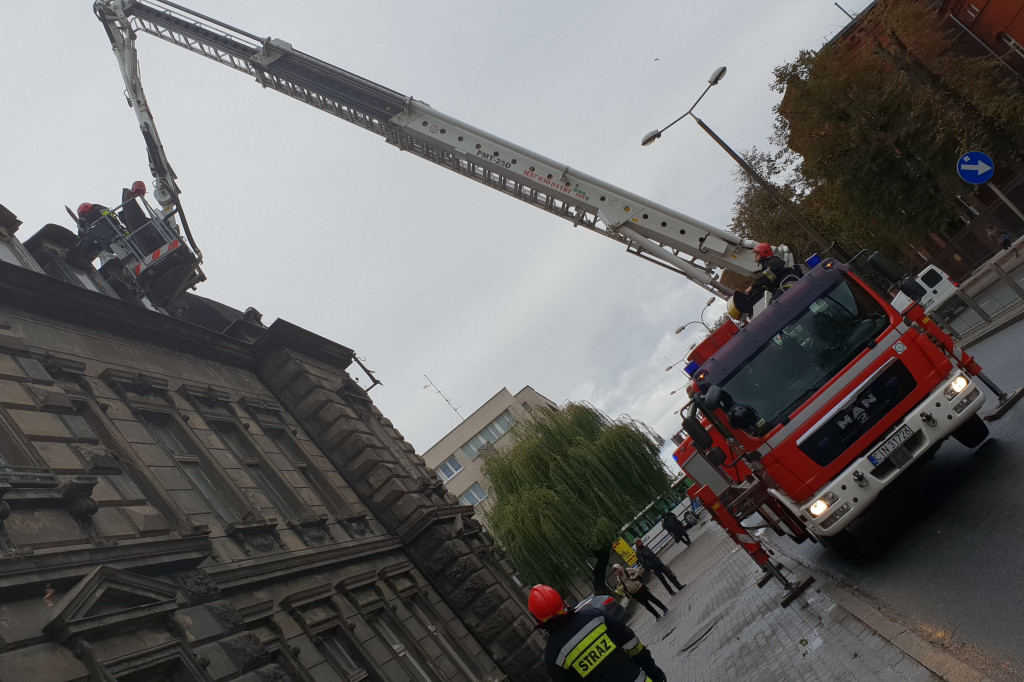 Stażacy usuwają części uszkodzonego dachu