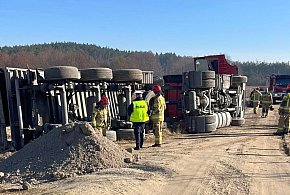 Ciężarówka przewróciła się na polu. Kierowca w kabinie