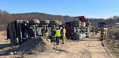Ciężarówka przewróciła się na polu. Kierowca w kabinie