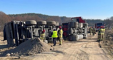 Ciężarówka przewróciła się na polu. Kierowca w kabinie