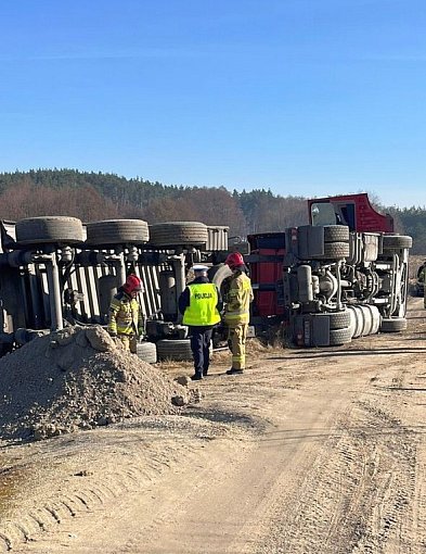 Ciężarówka przewróciła się na polu. Kierowca w kabinie