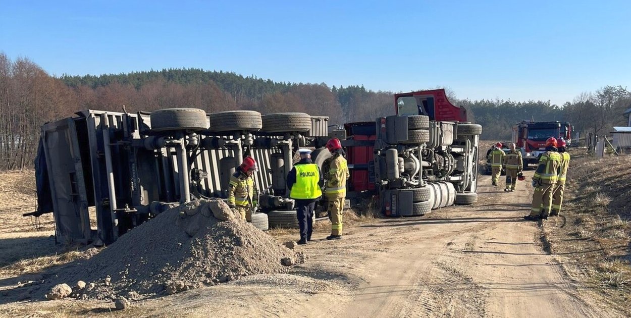 Ciężarówka przewróciła się na polu. Kierowca w kabinie